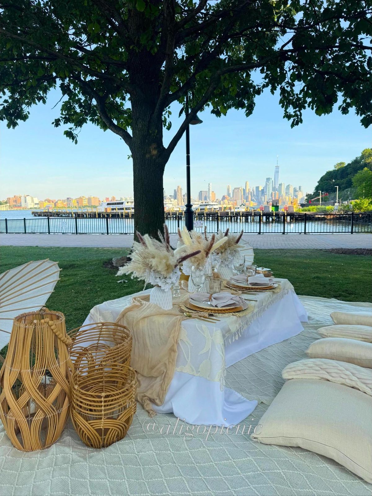 A boho picnic in cream with pampas, rattan lanterns and paper parasols on the Hudson waterfront